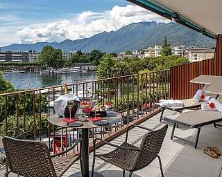 A balcony overlooking a lake with mountains in the background.