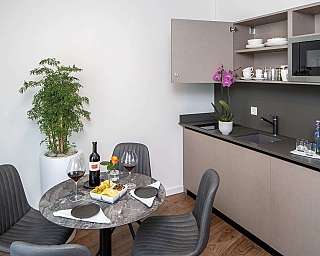Stylish kitchen with dining table, wine, and plants.