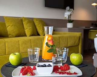 Plateau avec fruits frais et jus dans une chambre moderne.